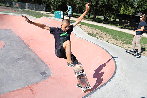Un jeune en train de faire une figure de skate dans le bowl
